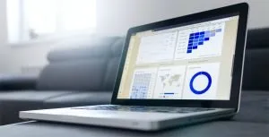 A photo of a laptop with various graphs displayed