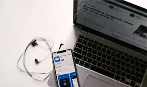 A photo of a laptop and phone downloading the Zoom app