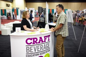 A photo of a man and woman engaging at a trade show.